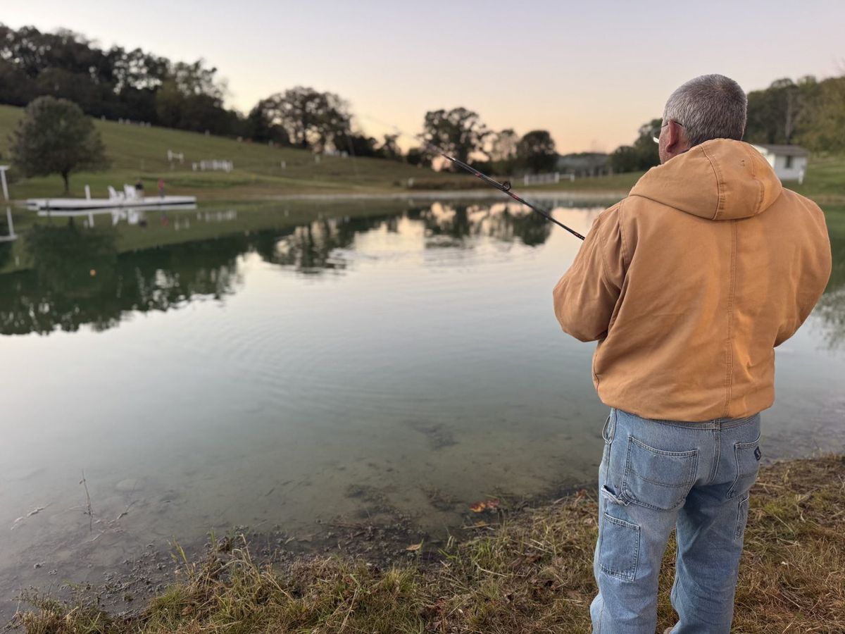 A guest casting a rod from the bank of the two-acre pond at Cedar Pond Farms at sunset