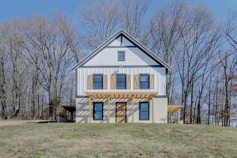 Barndo 2's cedar shutters and full-width pergola — the second of Fairland Ridge's three buildings at Cedar Pond Farms.