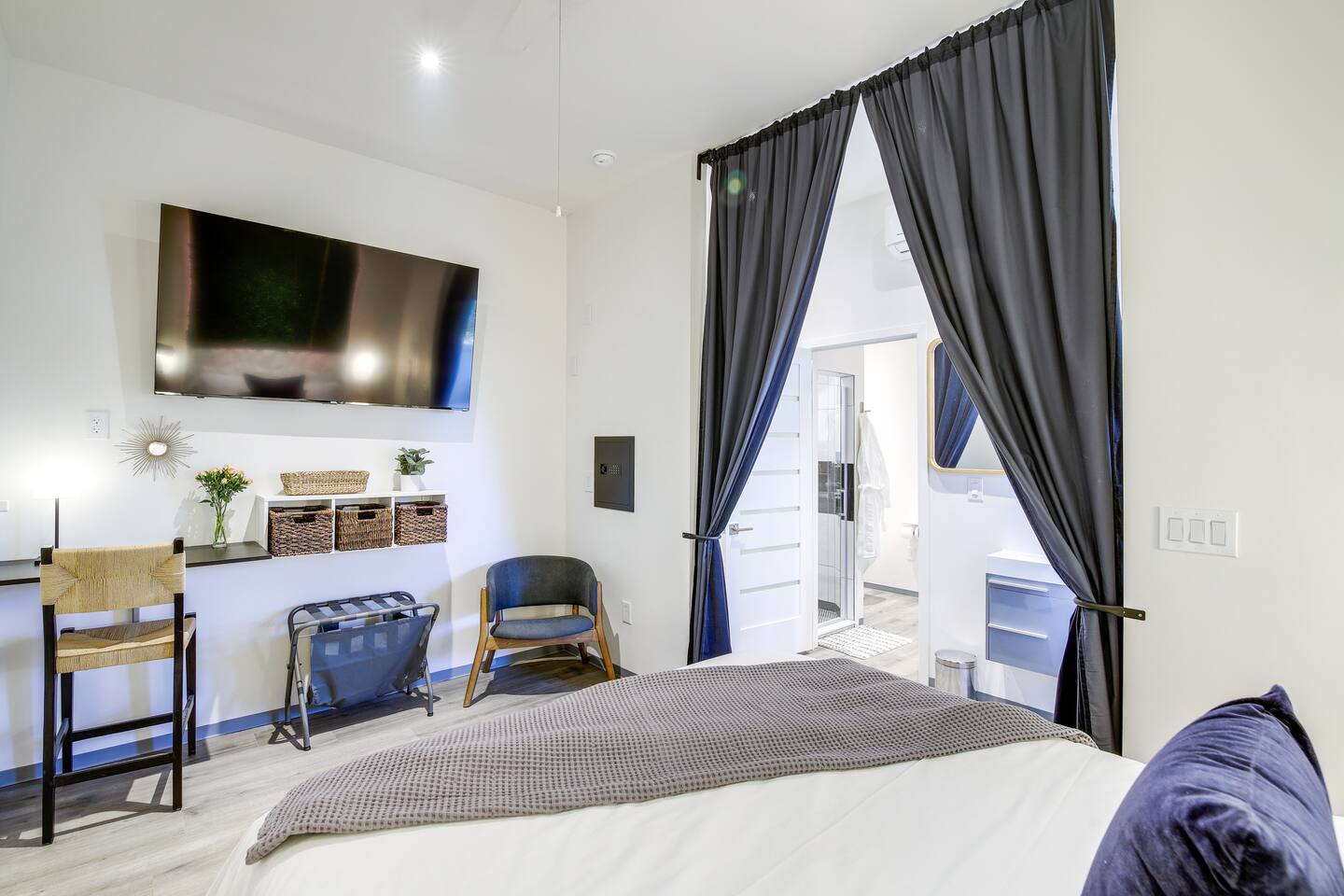 Enjoy a great nights sleep in this spacious but cozy modern bedroom.  Complete with a desk area, hand washing sink, smart TV, closet, indirect lighting, and queen-size bed.